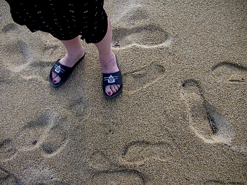 Footprints and feet on Elia Beach
